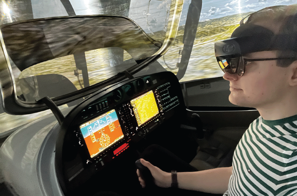 Picture of a pilot who tests the interaction with augmented en-route flight information through a mixed reality headset in a high-fidelity Diamond DA 40 simulator. The test pilot wears an augmented reality headset.