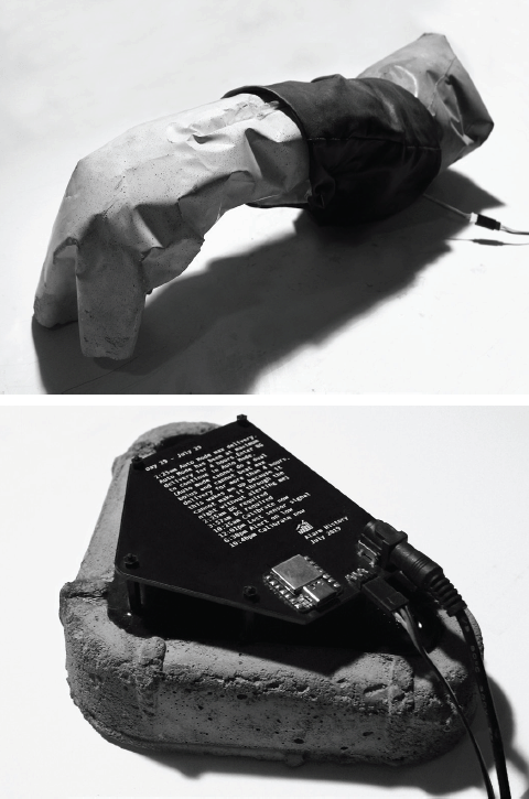 Top: A small gray concrete sculpture with a wide black spandex band in an organic shape similar to a human arm. Bottom: A small square circuit board with data from Laura's insulin pump printed on it mounted on a piece of concrete.