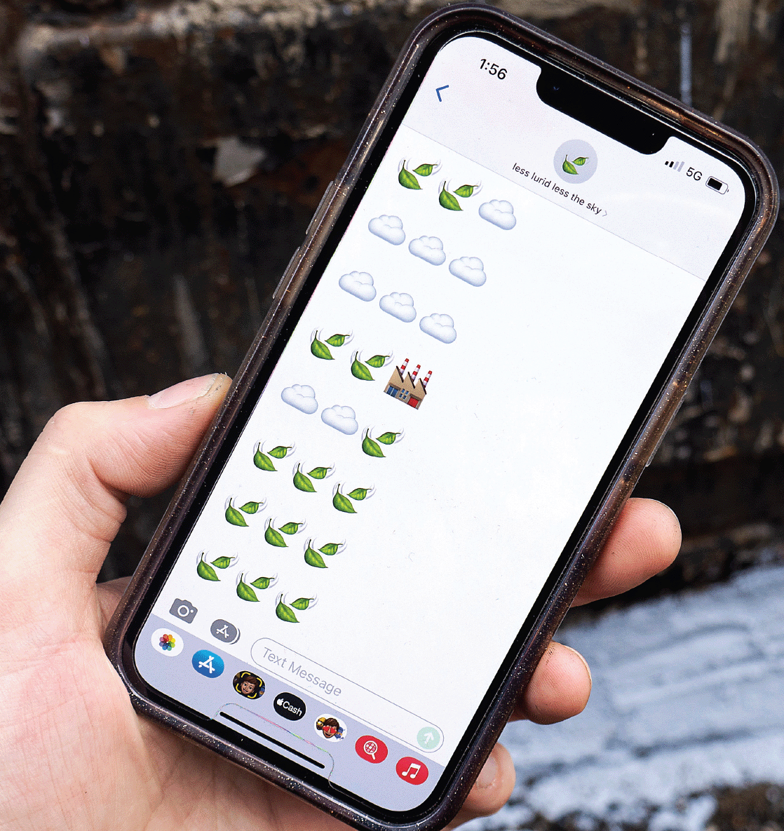 A white hand holds a phone in front of a coal chute; the phone displays an SMS message from "less lurid less the sky" of eight sets of three large emojis including clouds, falling leaves, and a factory.